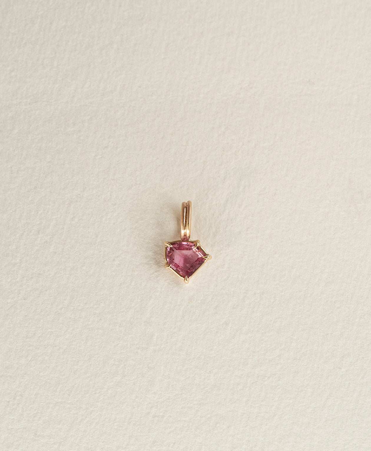 One of a Kind Charm 494 in 9k Yellow Gold featuring a vibrant fuchsia pink portrait cut Sapphire with a claw setting.