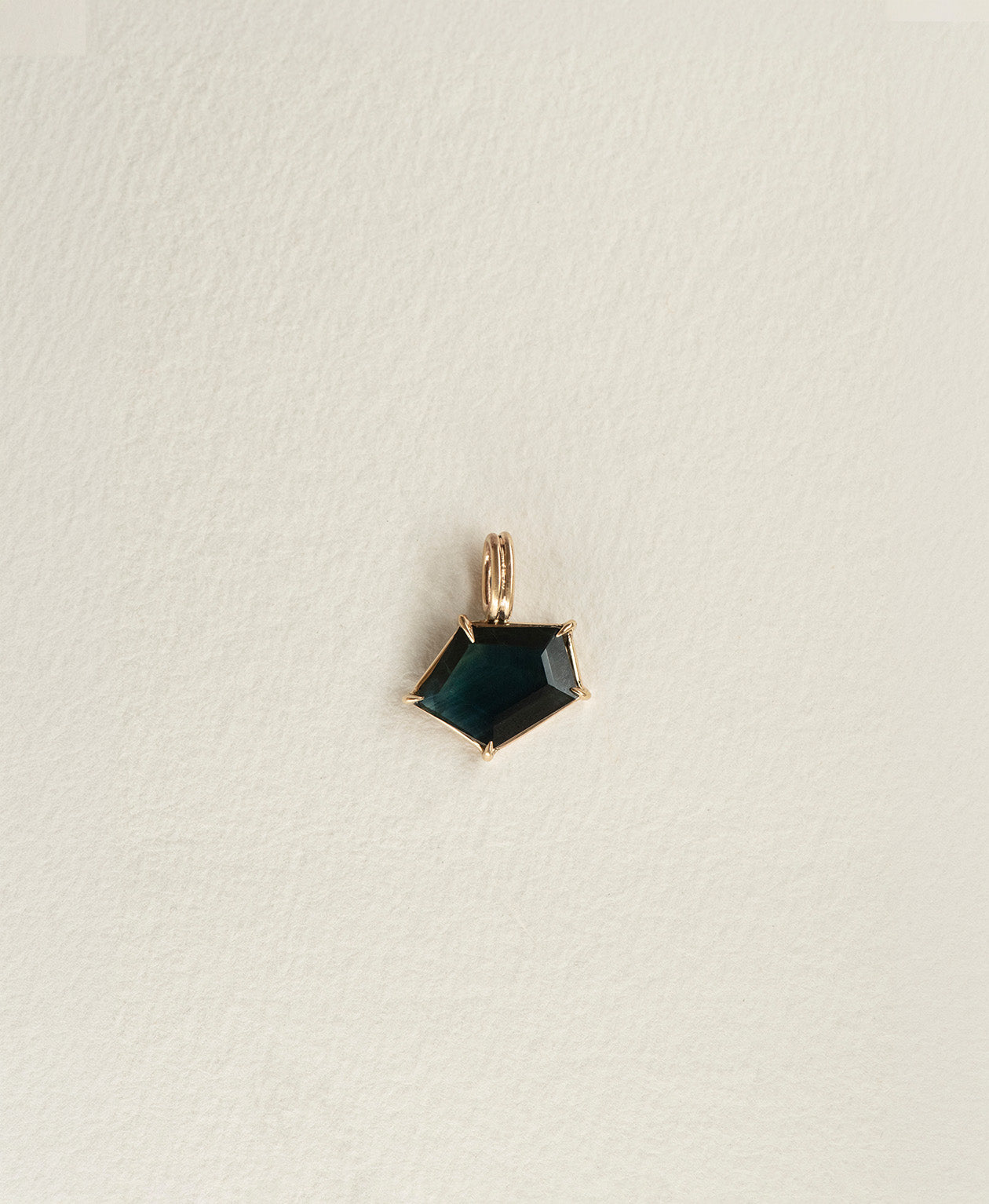 One of a Kind Charm 497 in 9k Yellow Gold featuring a dark teal portrait cut Sapphire with a claw setting.