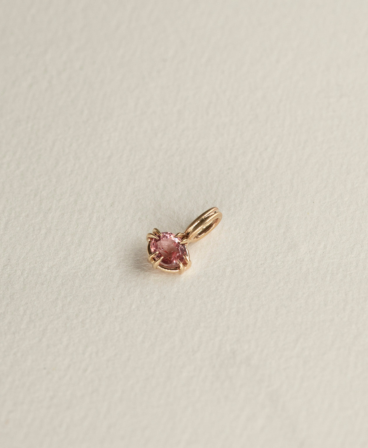 Angled view of the One of a Kind Charm 520 in 9k Yellow Gold with a pink oval cut Garnet.