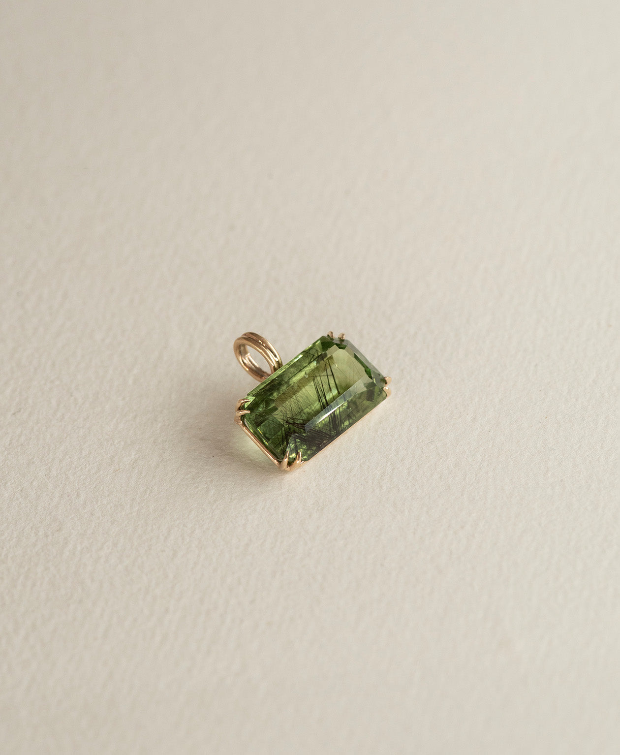Angled view of the One of a Kind Charm 513 in 9k Yellow Gold with a  deep green emerald cut Peridot.