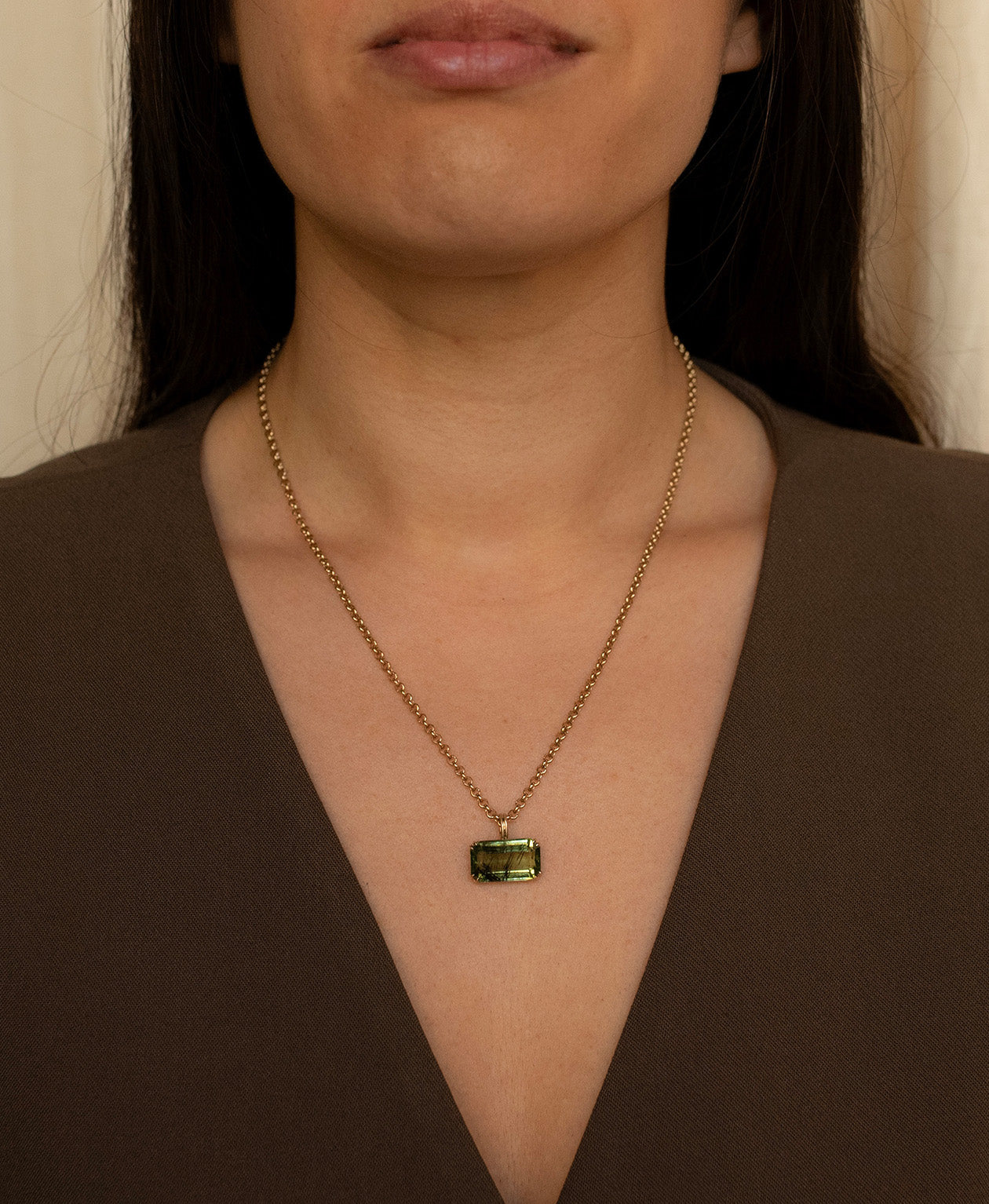 One of a Kind Charm 513 with a  deep green emerald cut Peridot worn by a model on a belcher chain. 